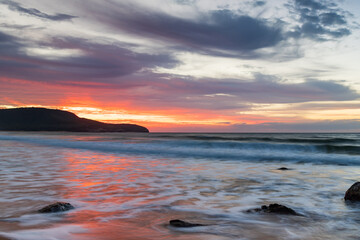 Sunrise at the seaside with pastel coloured clouds