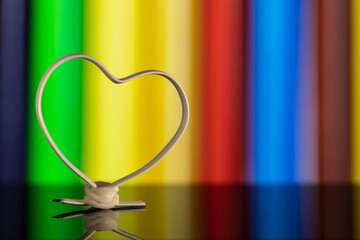 Heart shaped White wire on a colorful background.
