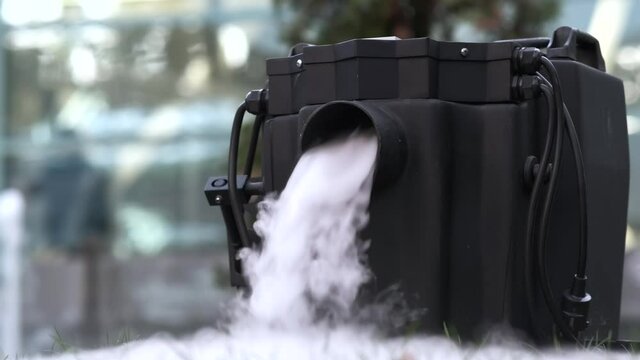 Smoke machine for heavy smoke after dancing. Thick smoke falls on the grass. Slow motion.