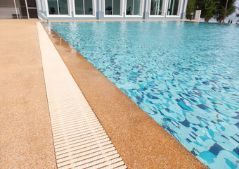 Close up with copy space of beautiful swimming pool with rock rim and blue clear water ripples...