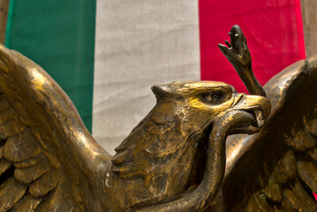 bandera de méxico con escultura de águila de bronce al frente