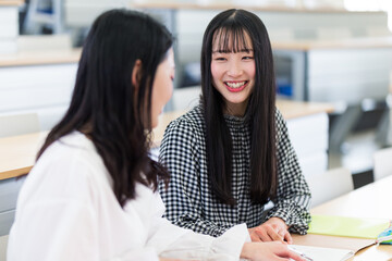 講義室で談笑する大学生