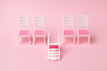 One fallen chair and four chairs standing in a row.