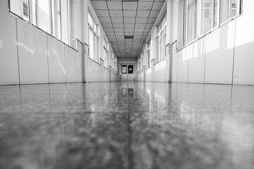 Sunlight shines on an empty hospital corridor in a monochrome photo