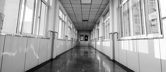 Sunlight shines on an empty hospital corridor in a monochrome photo