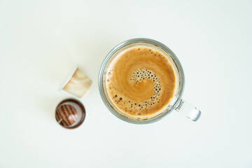 Beautiful texture on the surface of espresso crema in a cup on white table close up. 