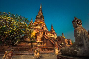 Fototapeta premium Background of old Buddha statues in Thai religious attractions in Ayutthaya Province, allowing tourists to study their history and take public photos.
