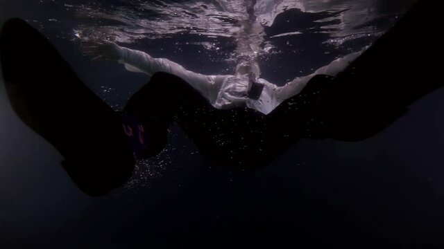 businessman is sinking in water of sea or river, underwater shot of man dressed suit