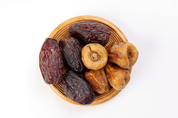 Ripe juicy dates fruit khurma variety black yellow on wooden saucer over white background