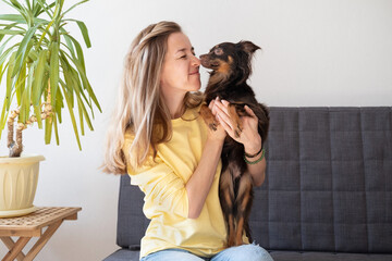 Happy blonde woman with funny brown russian toy terrier 