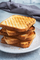 Bread toast crispy for sandwiches on a plate on a gray concrete table.