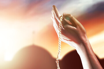 Muslim man praying with prayer beads on his hands