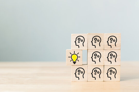 Concept creative idea and innovation. Wooden cube block with head human symbol and light bulb icon