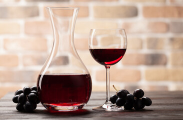 Wine decanter, glass of red wine and grapes