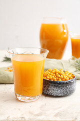 Glass of healthy sea buckthorn juice on white background