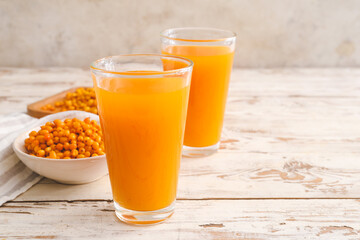 Glasses of healthy sea buckthorn juice on table