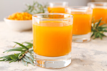 Glass of healthy sea buckthorn juice on grey background