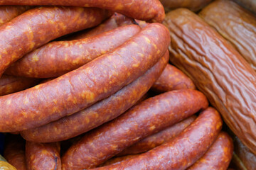 Smoked sausages for the backdrop. Finished meat in a shell with splashes of fat. Butcher shop concept.