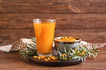Glass of healthy sea buckthorn juice on table