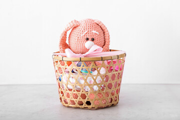 Wicker basket with gifts for baby on light background