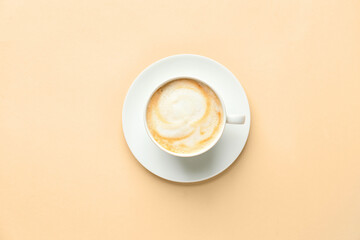 Cup of hot cappuccino coffee on color background