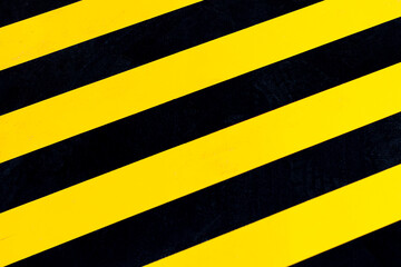 Yellow and black stripes on the floor of the warehouse. Top view, indoors horizontal shot.