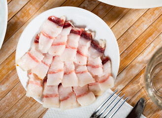 Traditional Ukrainian appetizer, homemade raw lard on a white plate