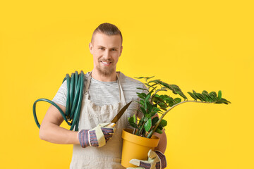 Young male gardener on color background