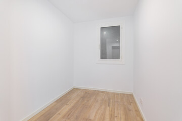 Empty room after renovation with white walls and dust window without natural light. Typical apartment in Barcelona.