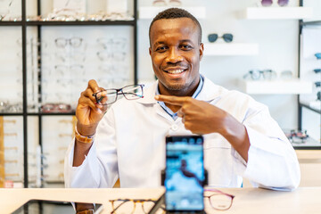African american attractive optician entrepreneur is vlogger or Blogger show fashion glasses to...