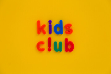 Kids or children club logo sign made from colourful letter sign poster on bright sunny yellow background. Play child playtime text from the alphabet words, place to stay for little baby invite label
