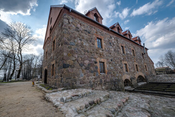 Fototapeta na wymiar the building of the restored old stone mill in early spring