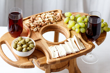 Serving wooden table for wine, glasses and snacks. Handmade segmented Portion wooden table. Grapes, cheese, wine and nuts.  
