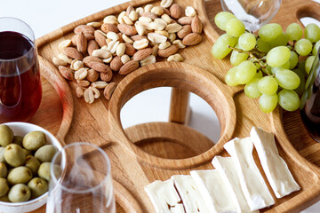 Serving wooden table for wine, glasses and snacks. Handmade segmented Portion wooden table. Grapes, cheese, wine and nuts.  