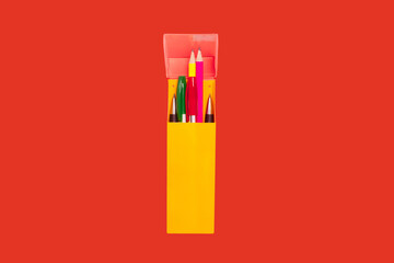 pens and pencils in a yellow box