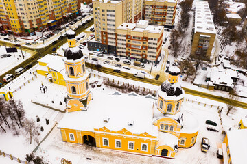 Aerial view of historic two domed building of Orthodox Cathedral of Intercession in Penza on background with modern residential area on winter day, Russia
