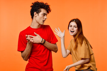 young couple in multicolored t-shirts joy cropped view orange background