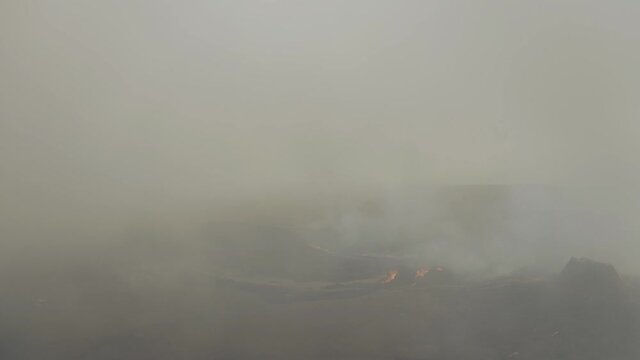 Aerial view through thick sulfur smoke at a volcano basin - reverse, drone shot