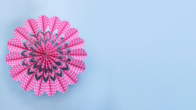 Pink flower made of paper bags on light grey background. Banner image with copy space 