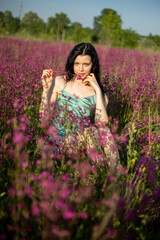 Girl in a turquoise dress in a blooming field