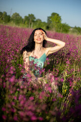Girl in a turquoise dress in a blooming field