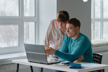 son shows his mother or grandmother how to create a personal page on the social network. seniors and technology concession.
