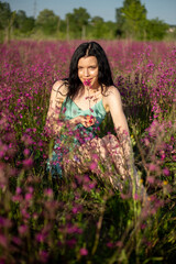 Fototapeta na wymiar Girl in a turquoise dress in a blooming field