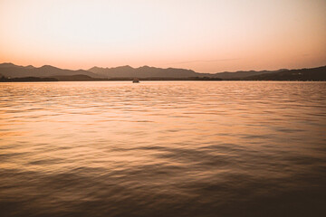 Panorama scenery of Morning fall nature misty foggy scene: forest with trees surrounded by  mist on the water surface of lake with hills and 
Leifeng Pagoda of West lake Hangzhou in the background.
