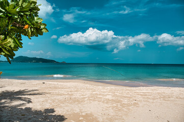 Empty, calm sandy crescent Patong Beach with turquoise blue clear water and cirrus cloudy sky