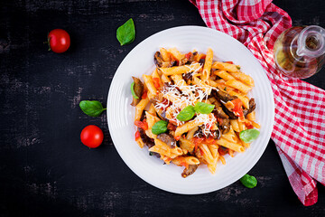 Pasta penne with eggplant. Pasta alla norma - traditional Italian food with eggplant, tomato, ricotta cheese and basil. Top view, overhead, copy space