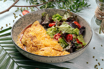 Side view on rustic omelette with vegetables salad