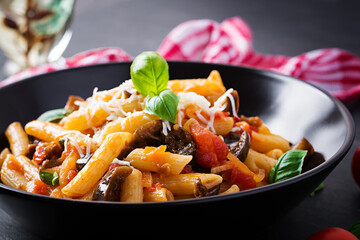 Pasta penne with eggplant. Pasta alla norma - traditional Italian food with eggplant, tomato, ricotta cheese and basil.