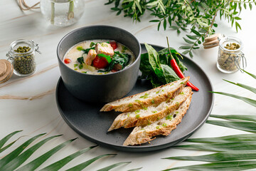 Creamy soup with salmon spinach and crispy french baguette