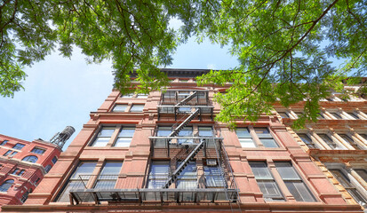 Looking up at an old building with fire escape, New York City, USA.
